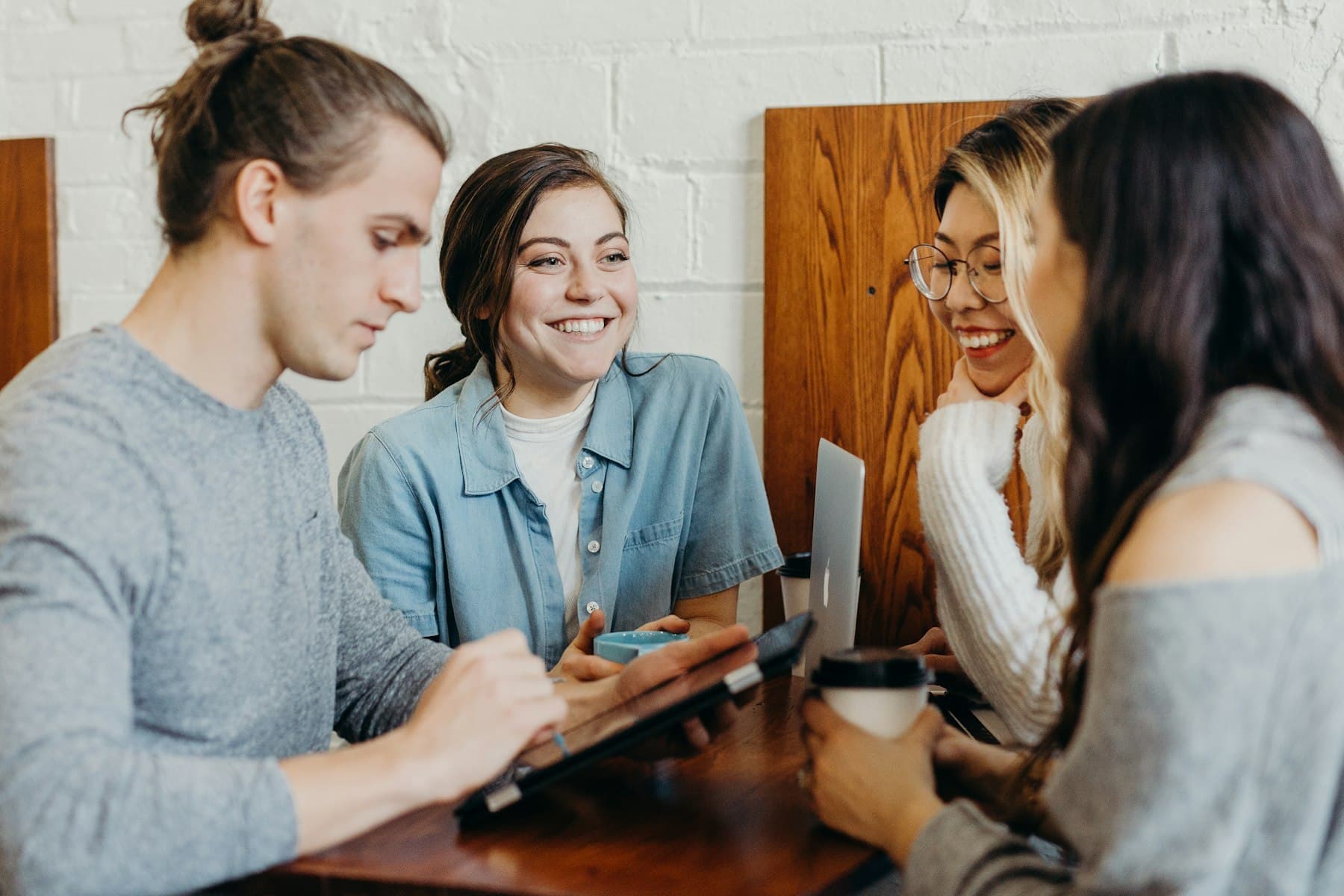Jeunes talents souriants échangeant autour d'une tablette